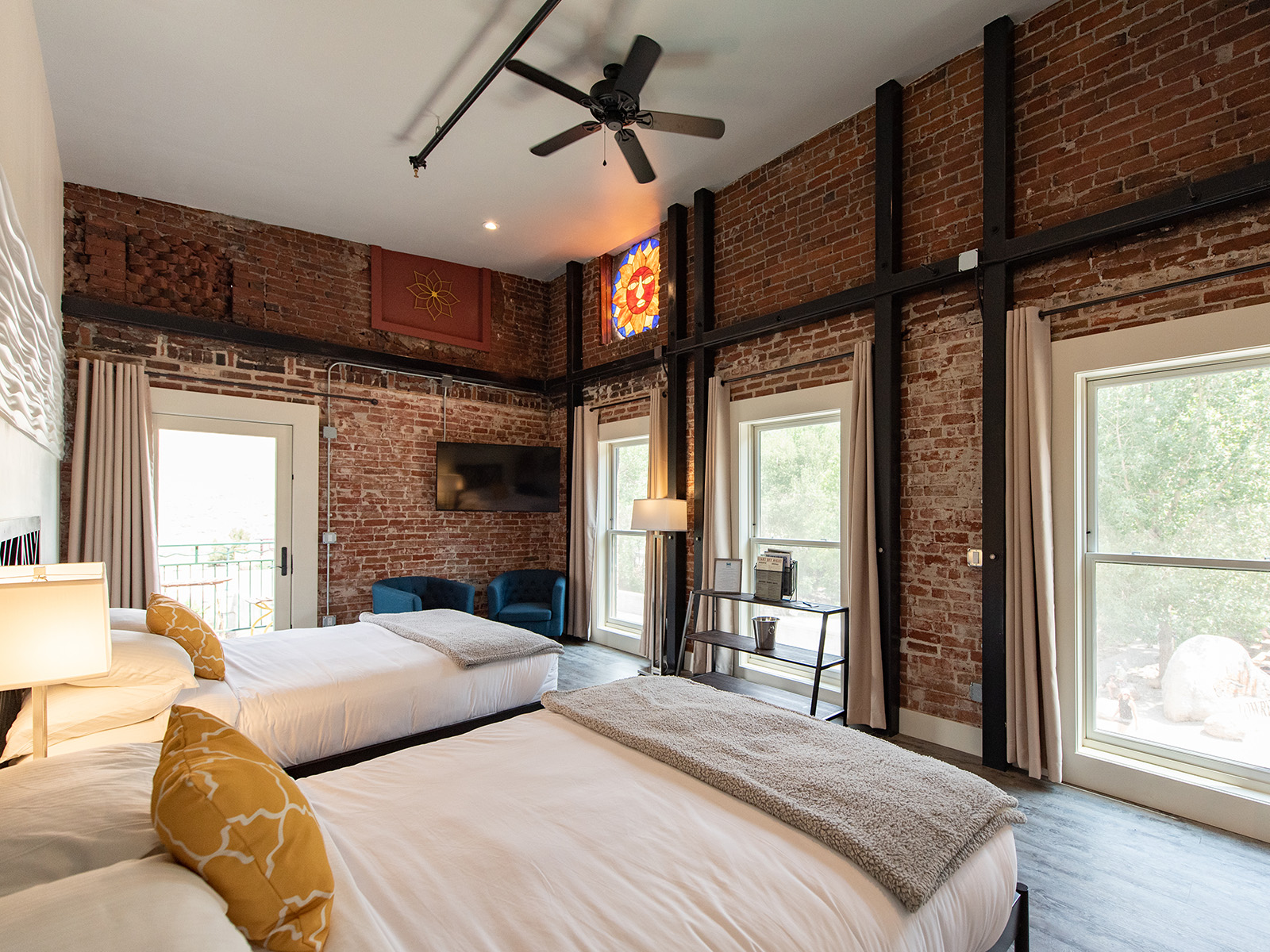 inside a brick hotel room with 2 queen beds