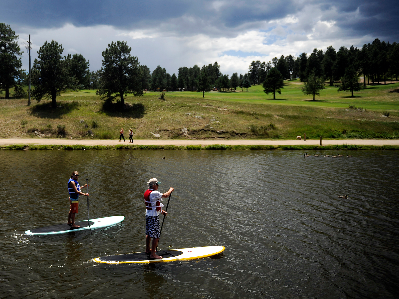 Two people paddleboard on Evergreen Lake