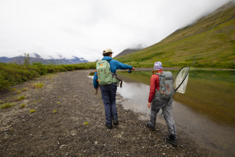two people picking their fishing spot, wearing Fishpond submersible bags