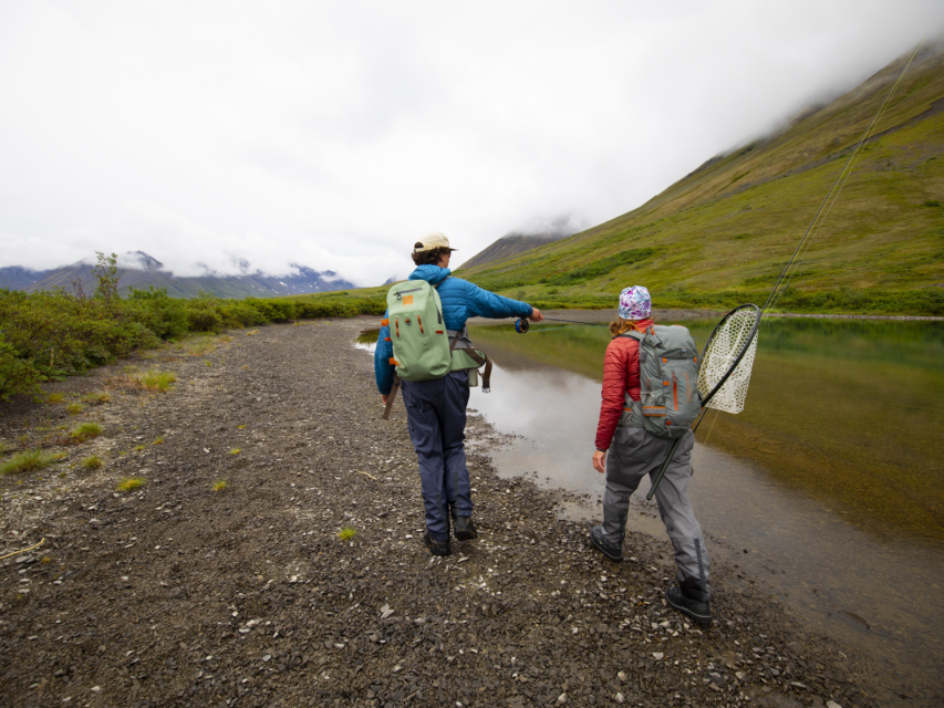 two people picking their fishing spot, wearing Fishpond submersible bags