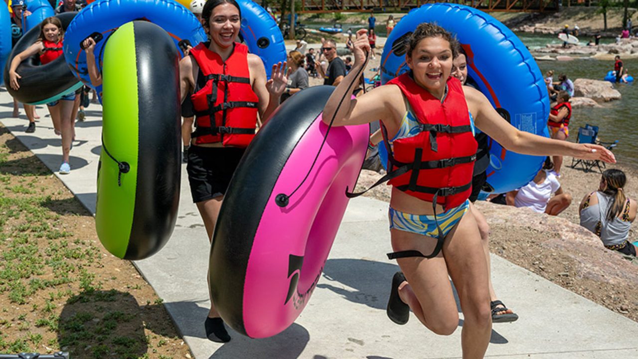 Kids running holding inner tubes