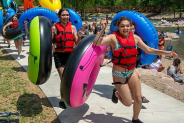 Kids running holding inner tubes