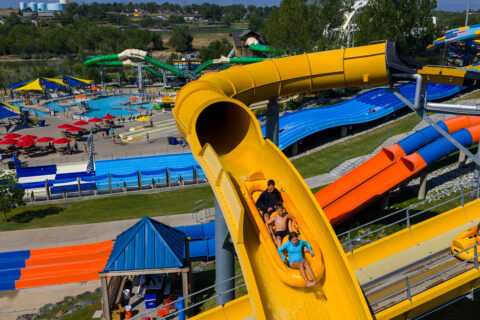 Three people ride down a tube water ride