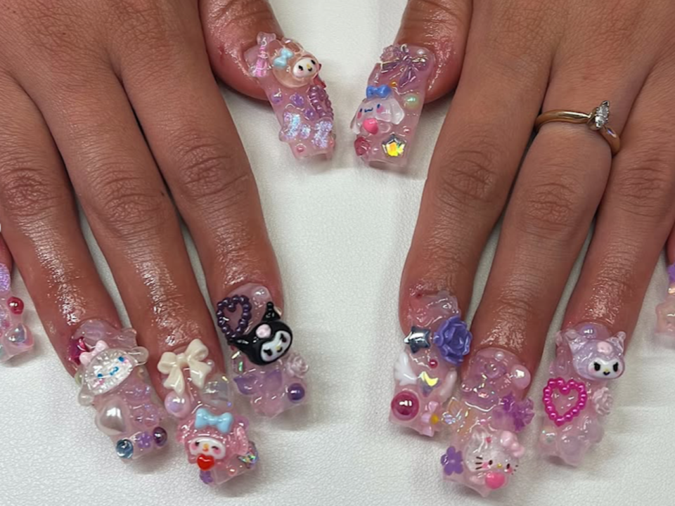 Chunky long nails bejeweled with gems and Hello Kitty charms