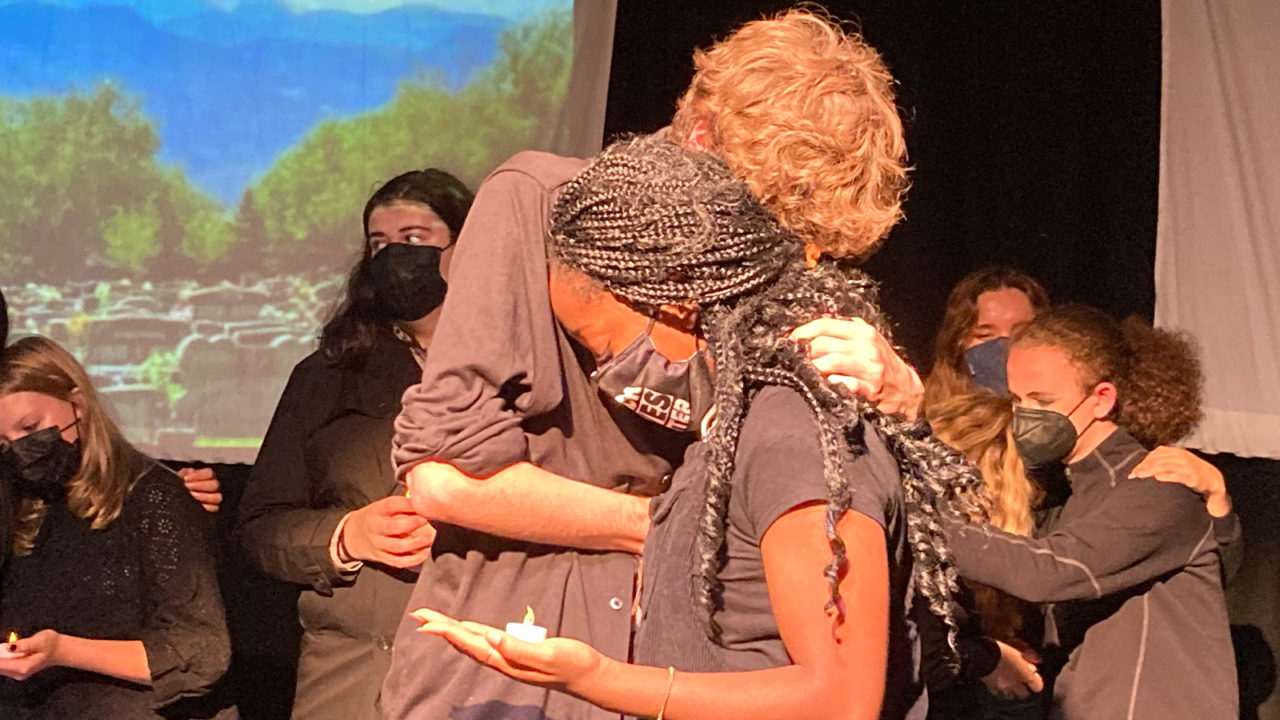 A white student consoles a Black student during a performance of re:ACTION, a play written during the pandemic by Denver School of the Arts students.