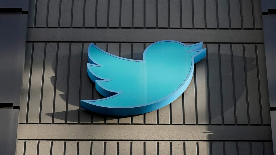 The blue Twitter bird logo on a gray building.