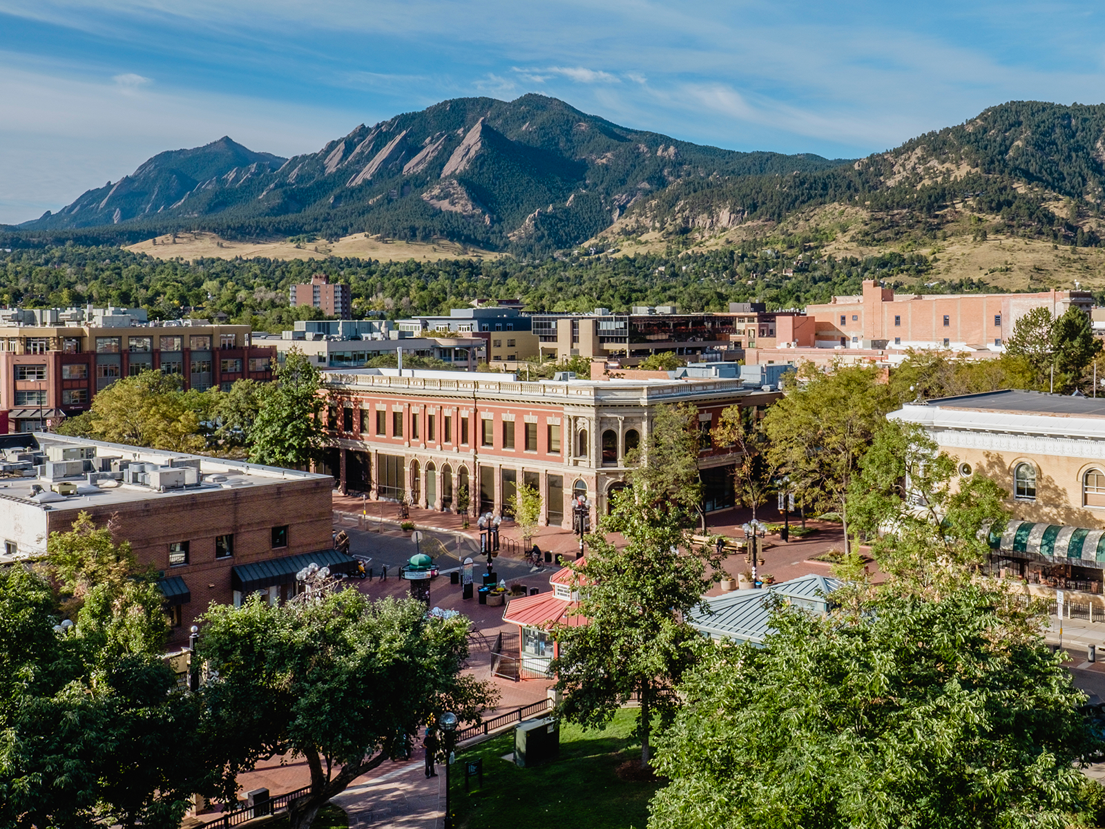 An aerial view of Downtown Boulder with Flatirons in the back
