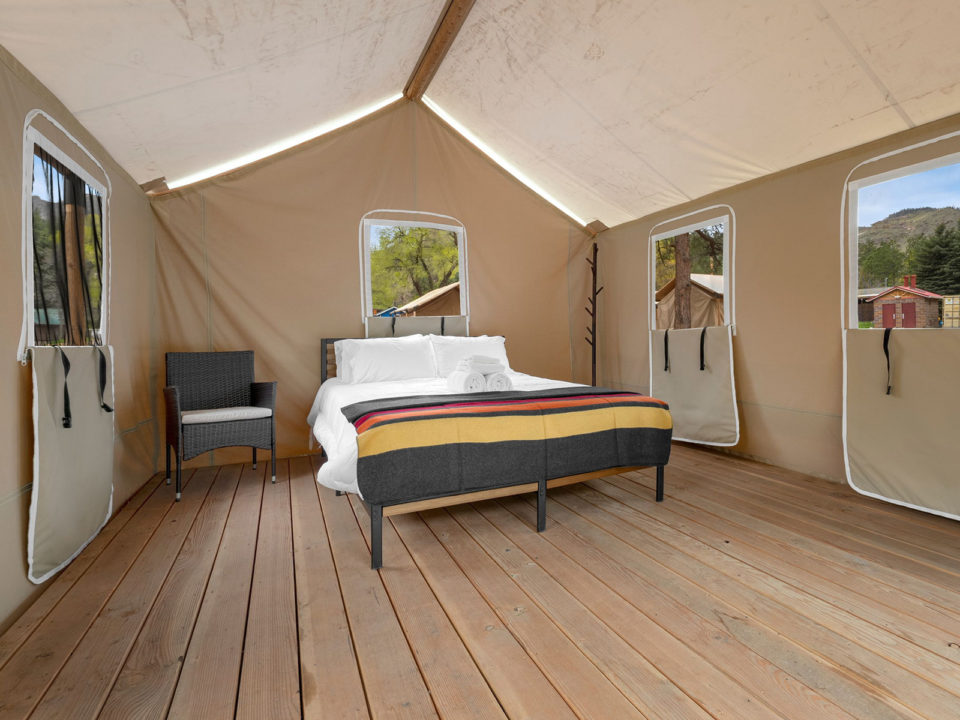 Queen-size bed inside a glamping tent