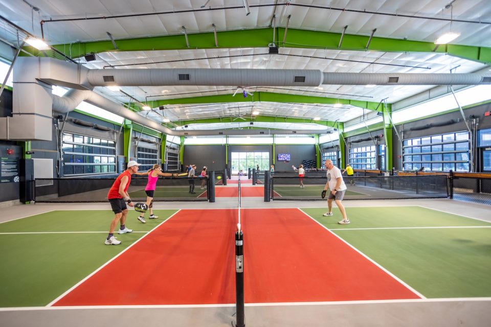 Players on indoor pickleball courts.