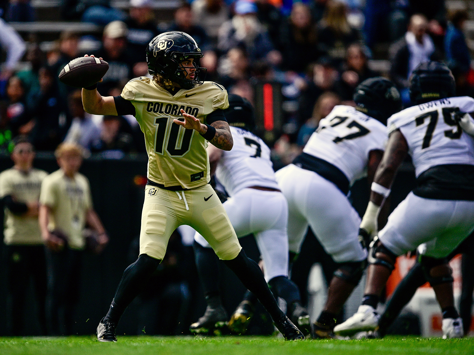 Quarterback Julian Lewis wearing gold and passing the football
