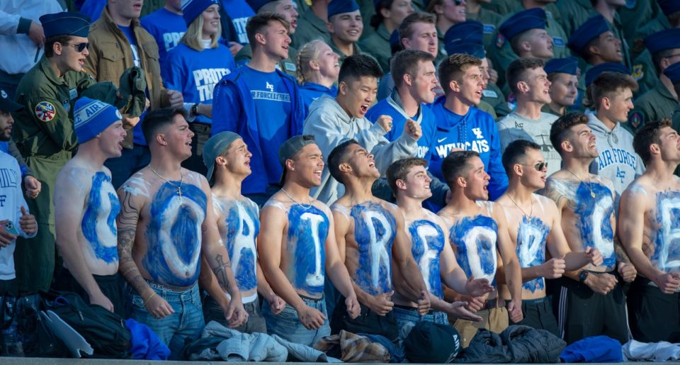 Shirtless fans with Go Air Force painted on their chests in blue and white