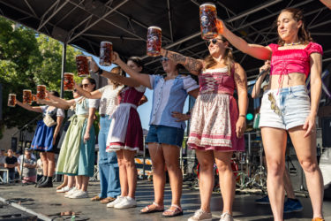 People dressed in German clothes compete in a stein-hoisting competition