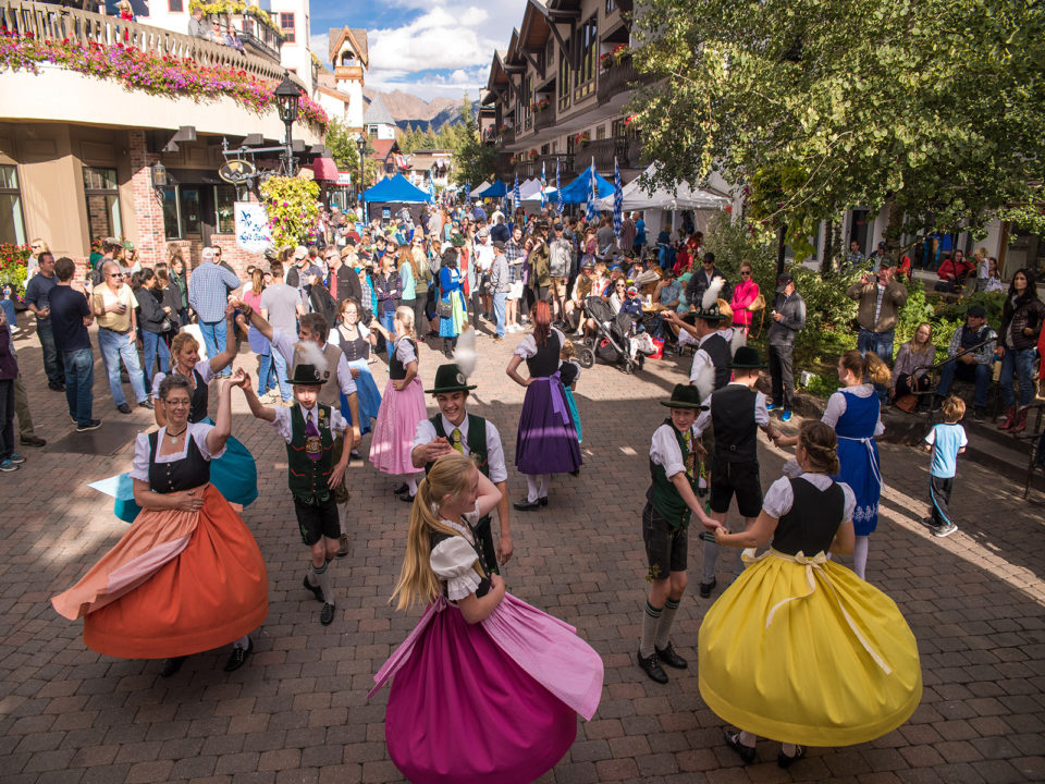 People dressed in German clothes dance in Vail Village