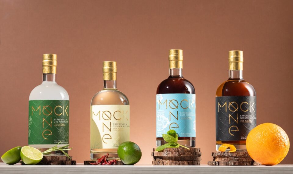 Four bottles of non-alcoholic spirits with cocktail garnishes