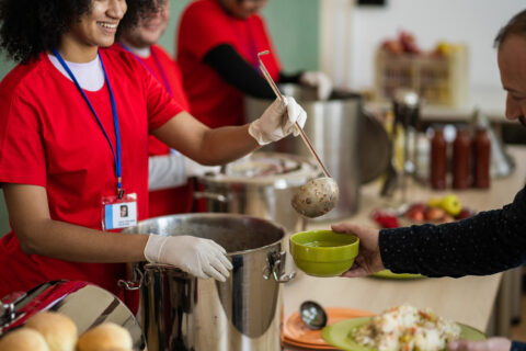 Happy volunteer serves food