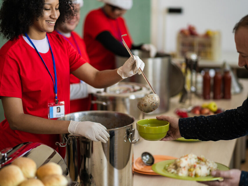 Happy volunteer serves food
