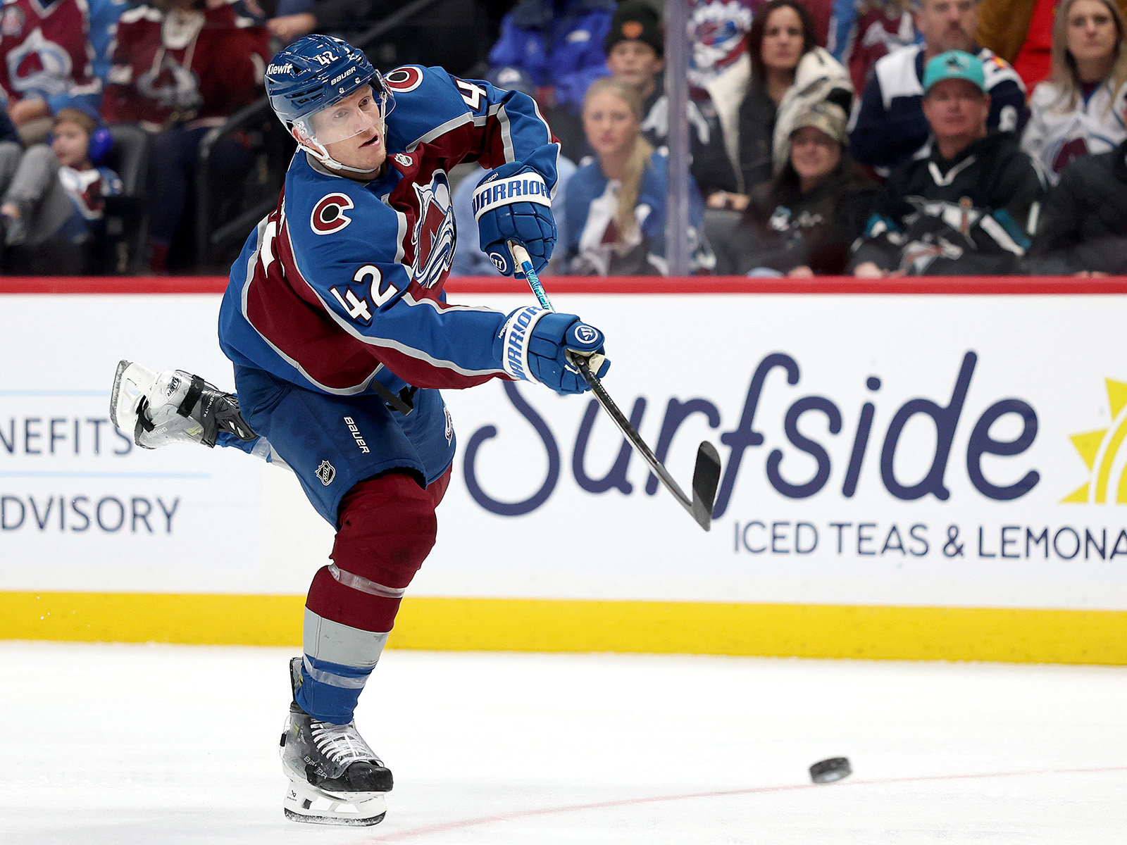 Josh Manson shoots a puck