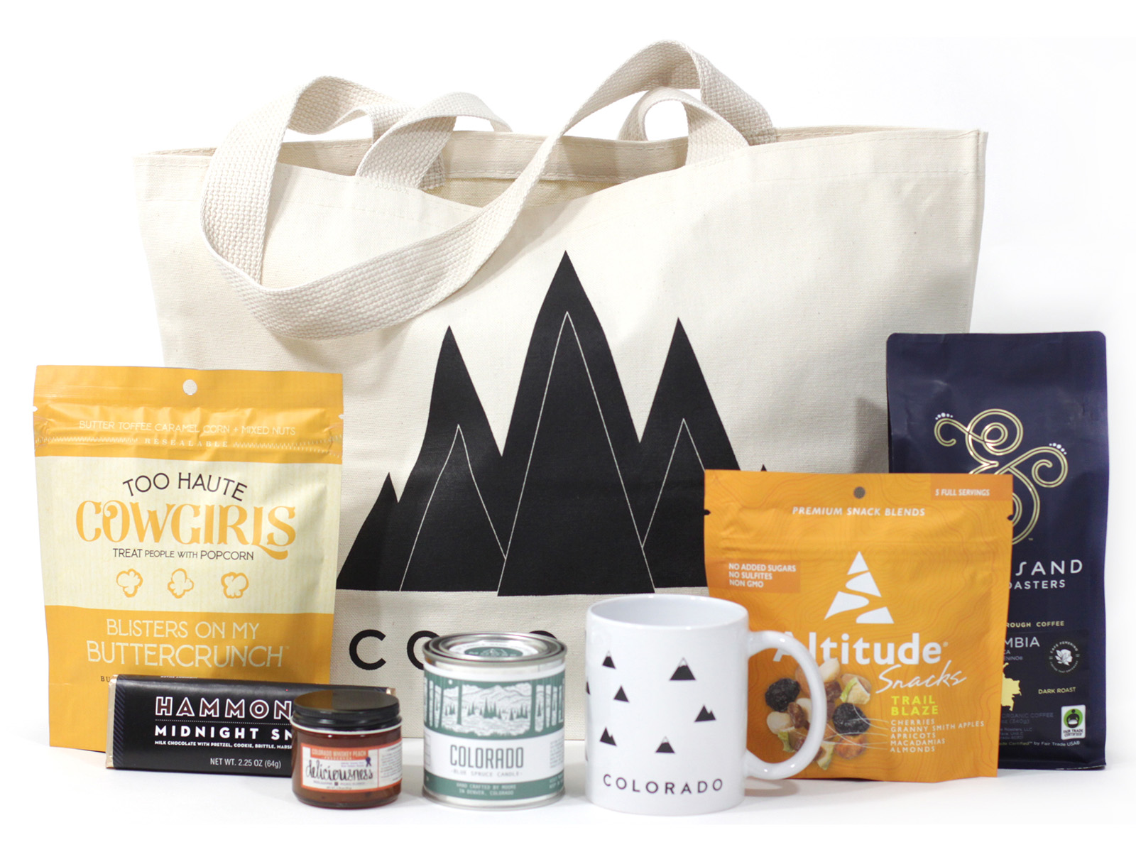 Mountain tote bag with Colroado snacks and a Colorado mug in front of it