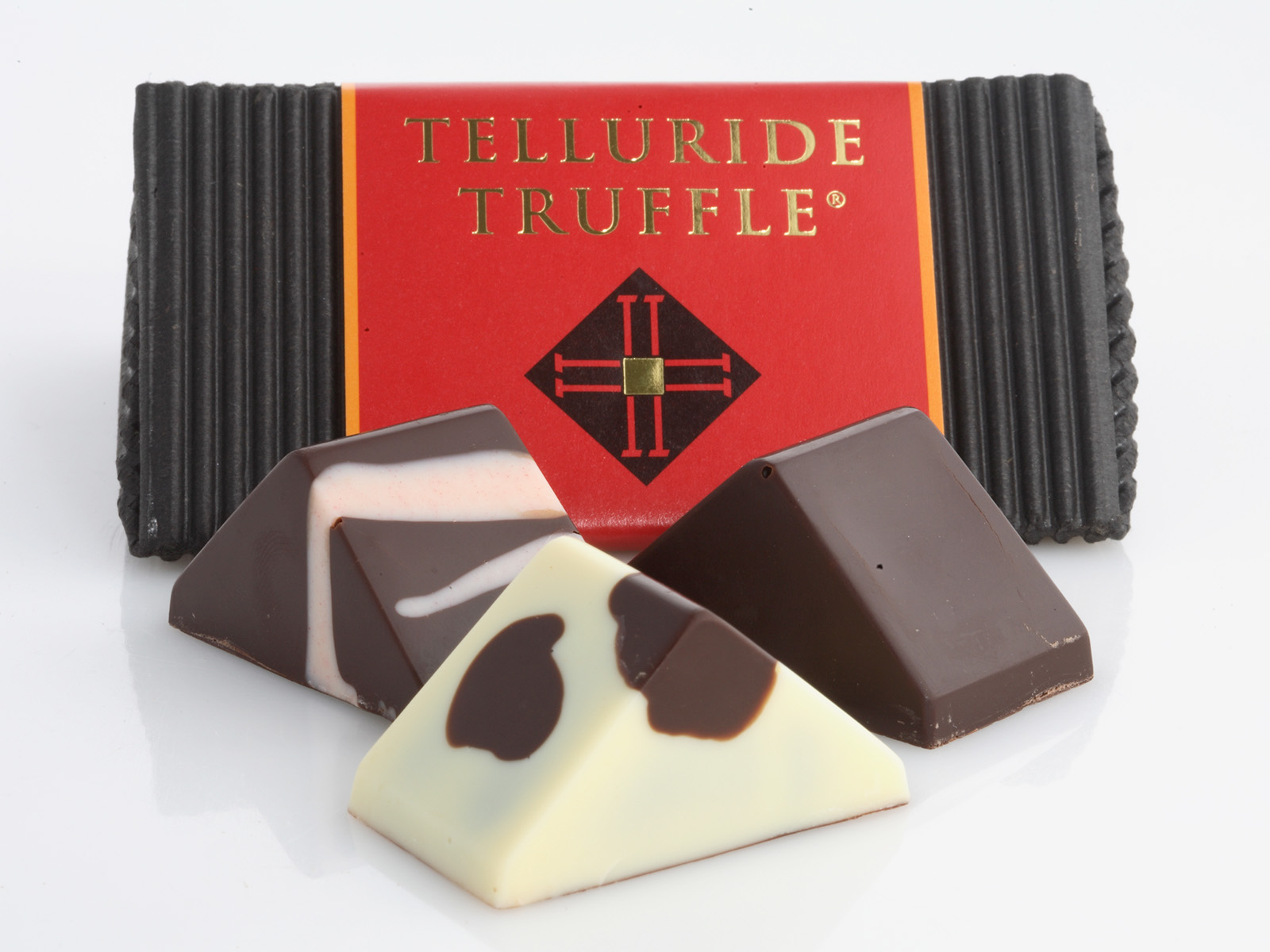 Three truffles sit in front of a Telluride Truffle box