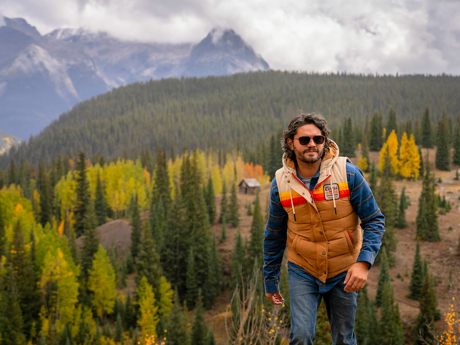 Man walking in the mountains with a color-blocked vest