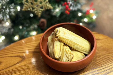 A bowl of tamales in front of a Christmas tree
