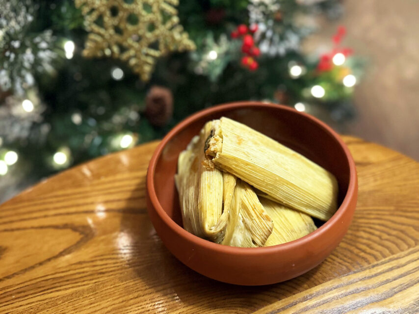 A bowl of tamales in front of a Christmas tree