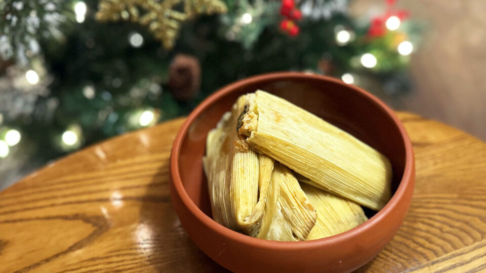 A bowl of tamales in front of a Christmas tree