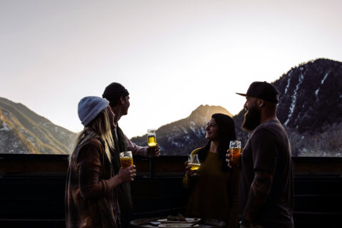 Four people enjoying après at Outer Range Brewing off I-70