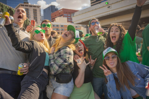 Young adults dressed in green and drinking beer