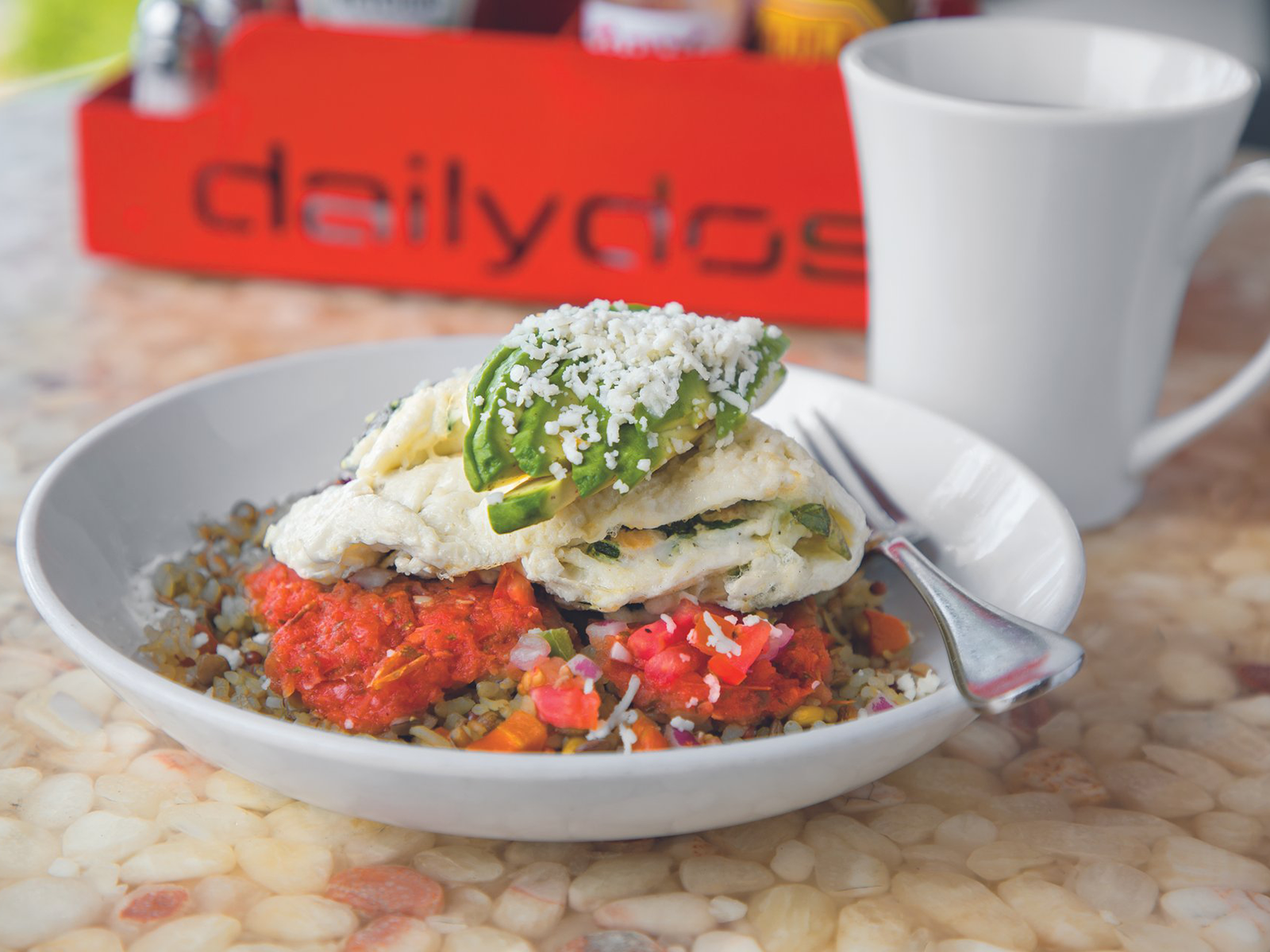 Breakfast bowl with grains, eggs, and avocado