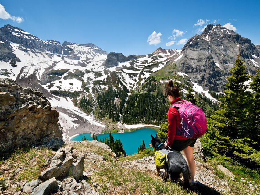A girl and her pup hiking in the San Juans above Blue Lake