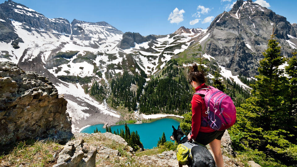 A girl and her pup hiking in the San Juans above Blue Lake