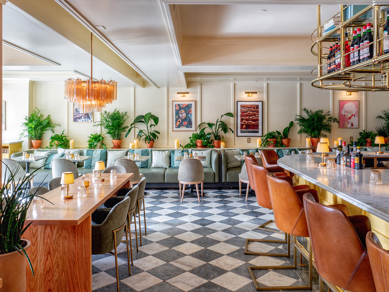 Restaurant with a checkered floor and mint green banquettes, leather bar stools