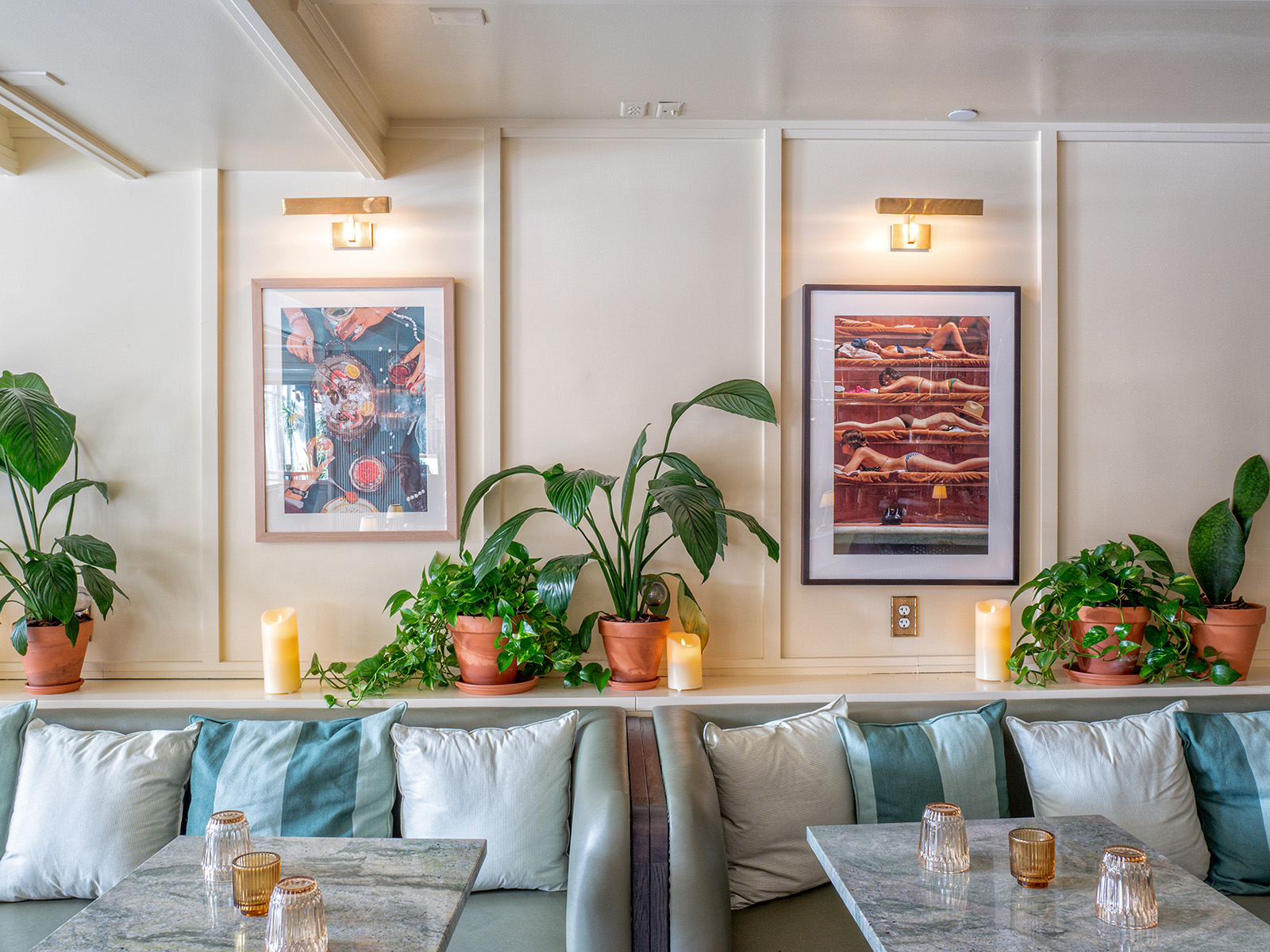 Mint green banquettes with framed artwork on the wall behind it