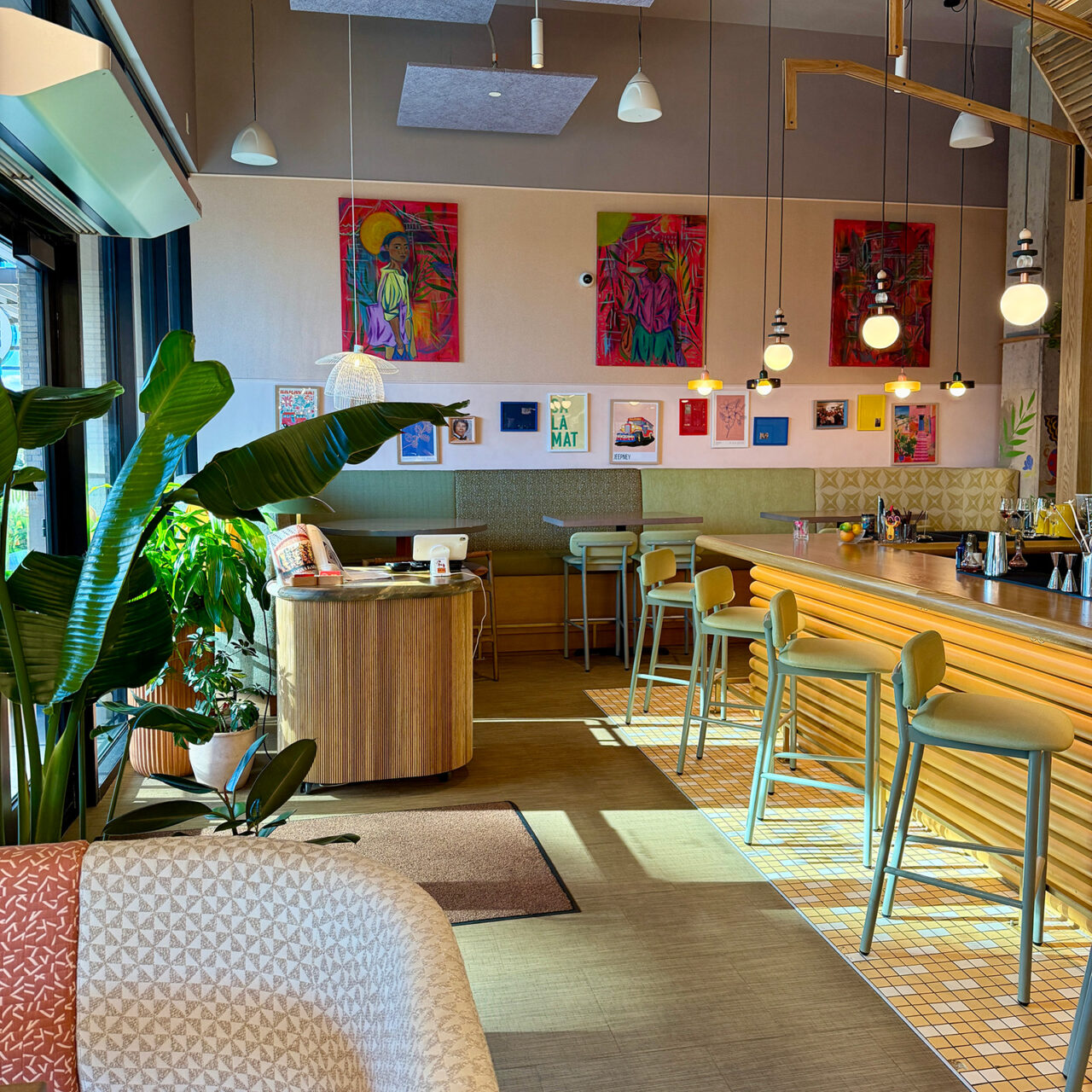 Trio of paintings hang on the wall of a restaurant dining room