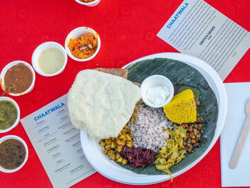 A tray of food from Chaatwala with cups of sauces beside it