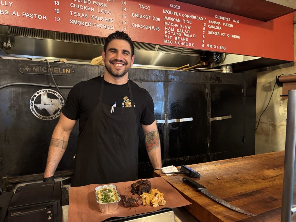 Riot BBQ co-owner Manny Barella serves barbecue at his new restaurant.