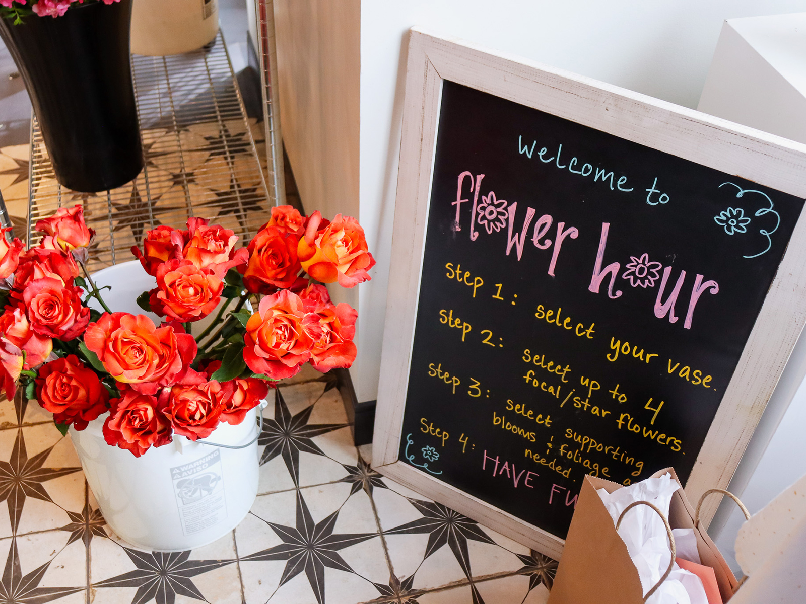 Flower hour welcome sign and vase of flowers at Rowdy Poppy