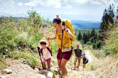 Family hiking with a mom and daughter at the forefront