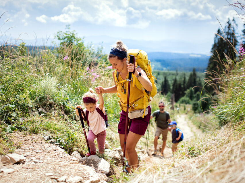 Family hiking with a mom and daughter at the forefront