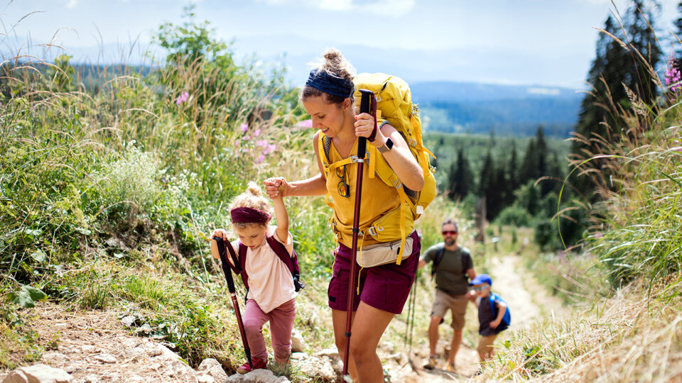 Family hiking with a mom and daughter at the forefront