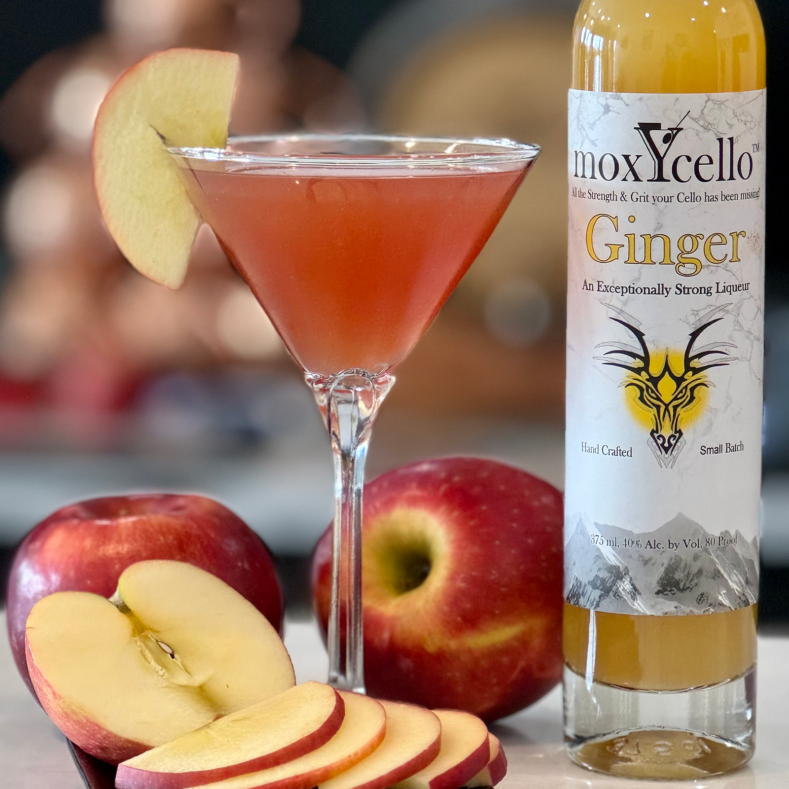 Bottle of Moxycello Ginger liquer beside a martini