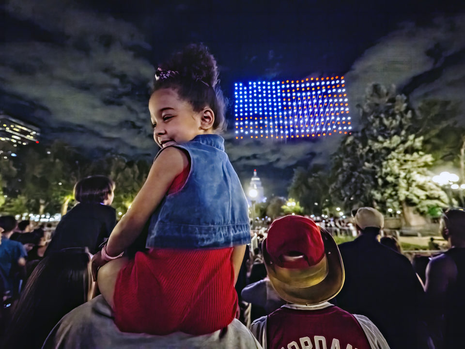A young girl watches a drone show in Denver for Fourth of July