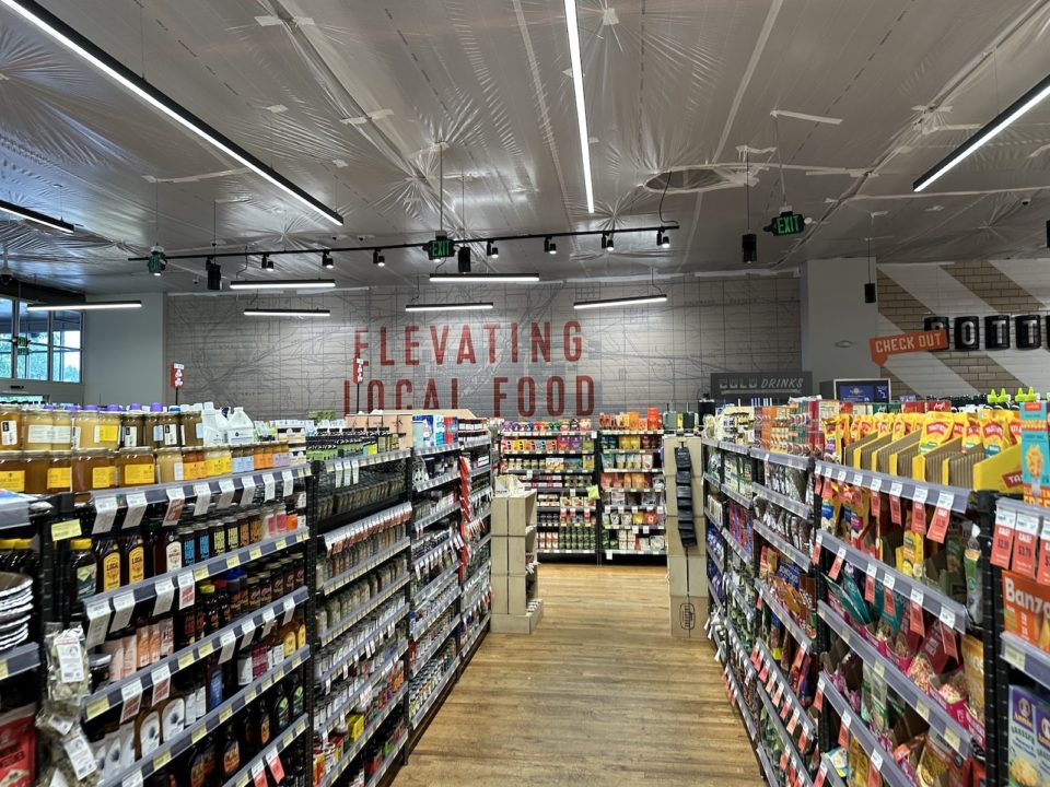 Aisles of dry goods at Leevers Locavore and a sign that reads "Elevating local food"