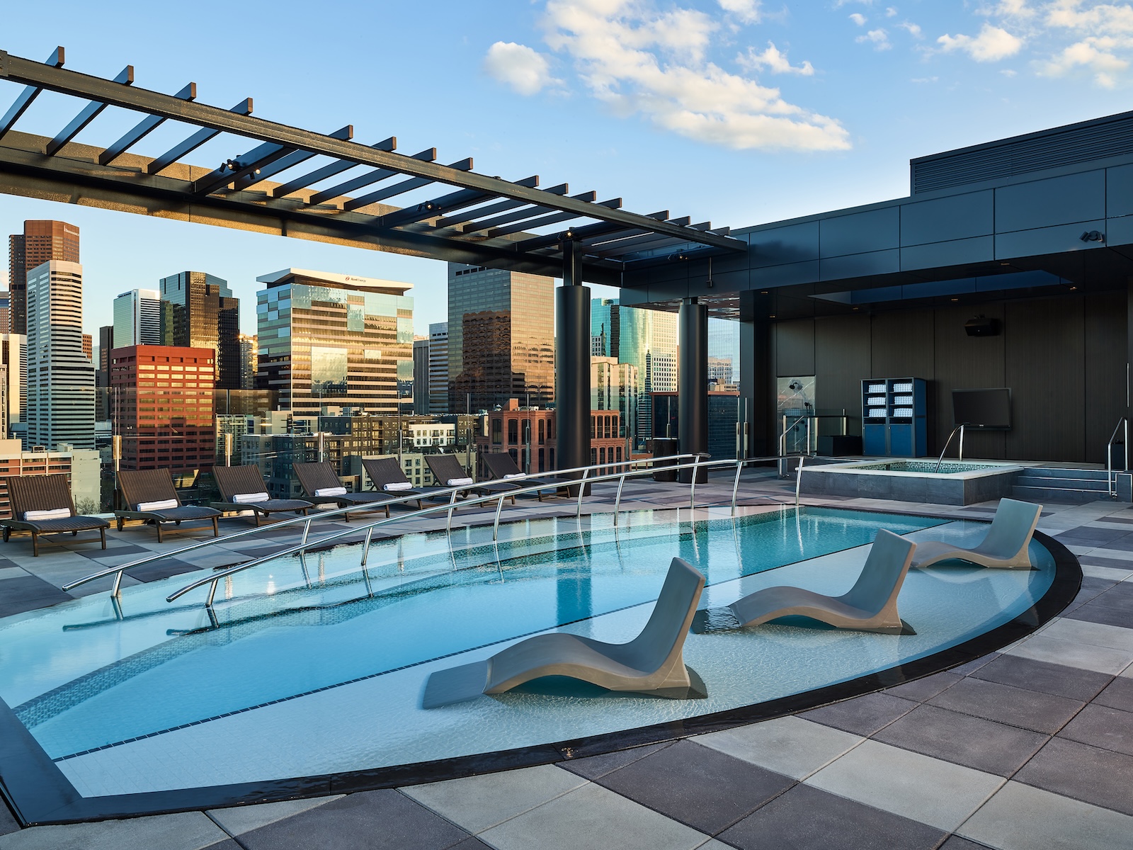 A rooftop plunge pool backgrounded by the Denver skyline