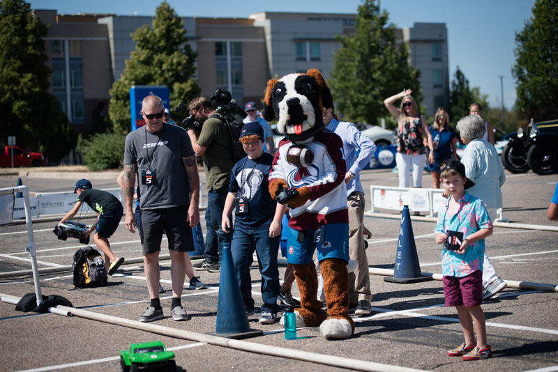 A group of people standing by a dog mascot outside