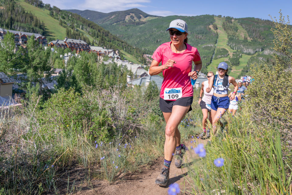 A group of runners jog uphill