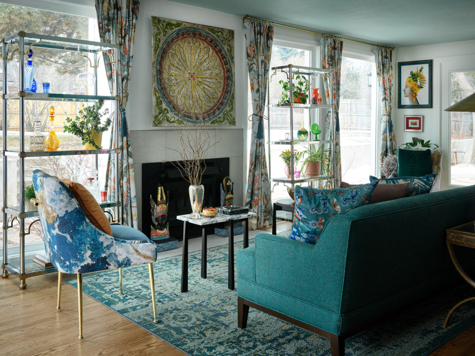Sunroom filled with blue furniture, colorful curtains and artwork