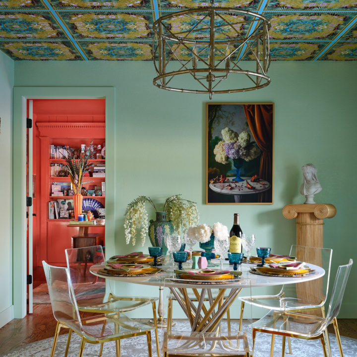 Mint green dining room with Versace wallpaper on the ceiling and a gold chandelier