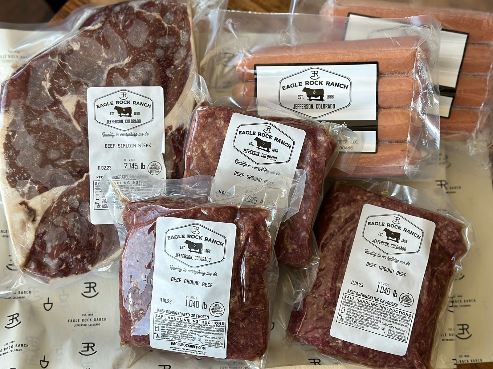 Assortment of packaged meats including hot dogs, ground beef, and steaks